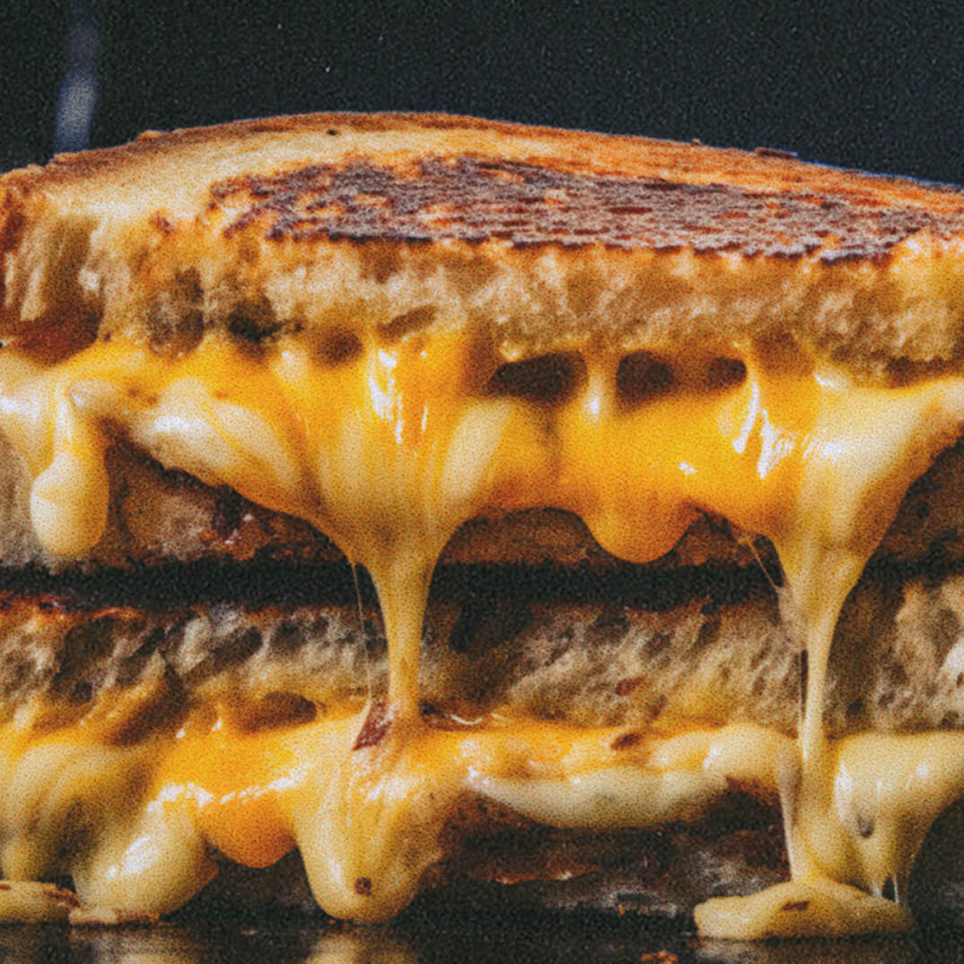 Grilled cheese cut in half and oozing