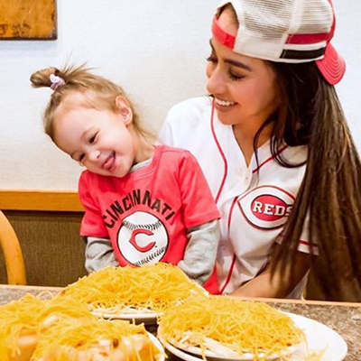 Child sitting on adult woman's lap smiling at her skyline food